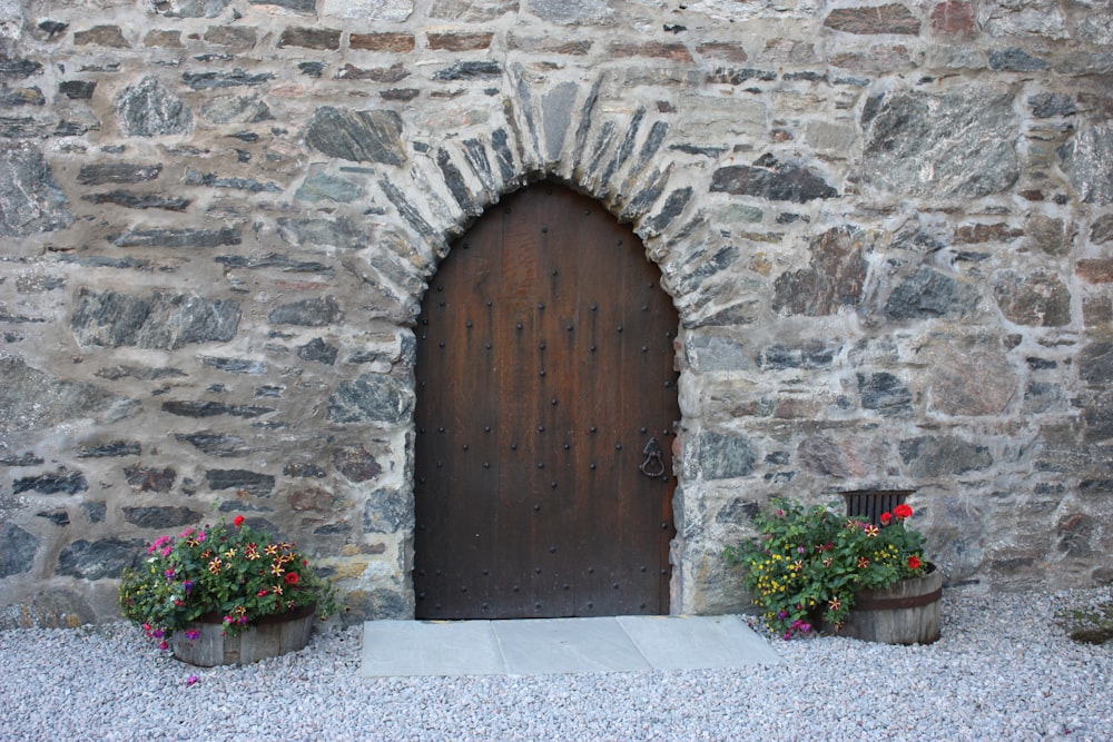 puerta de madera marrón sobre pared de ladrillo gris