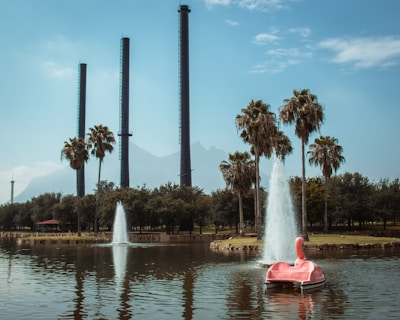 person in red kayak on water fountain during daytime