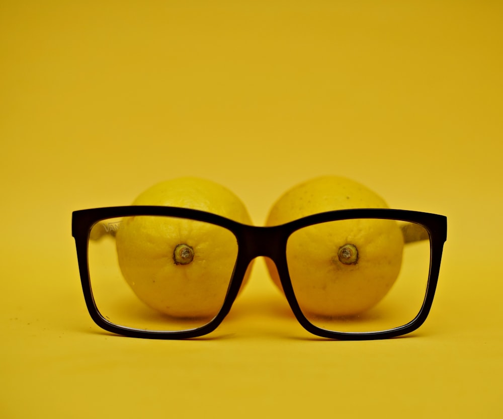 black framed eyeglasses on yellow surface