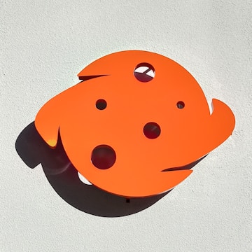 An abstract sculpture casting intricate shadows on a minimalist white wall.