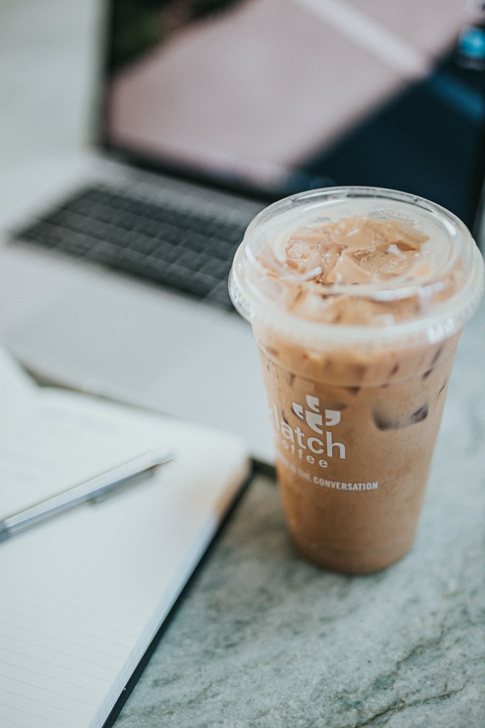 brown and white disposable cup on white table