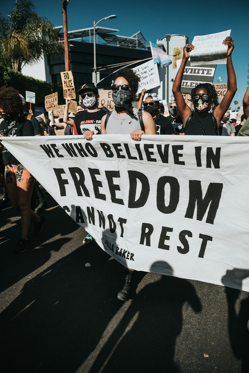 woman in black tank top holding white and black banner