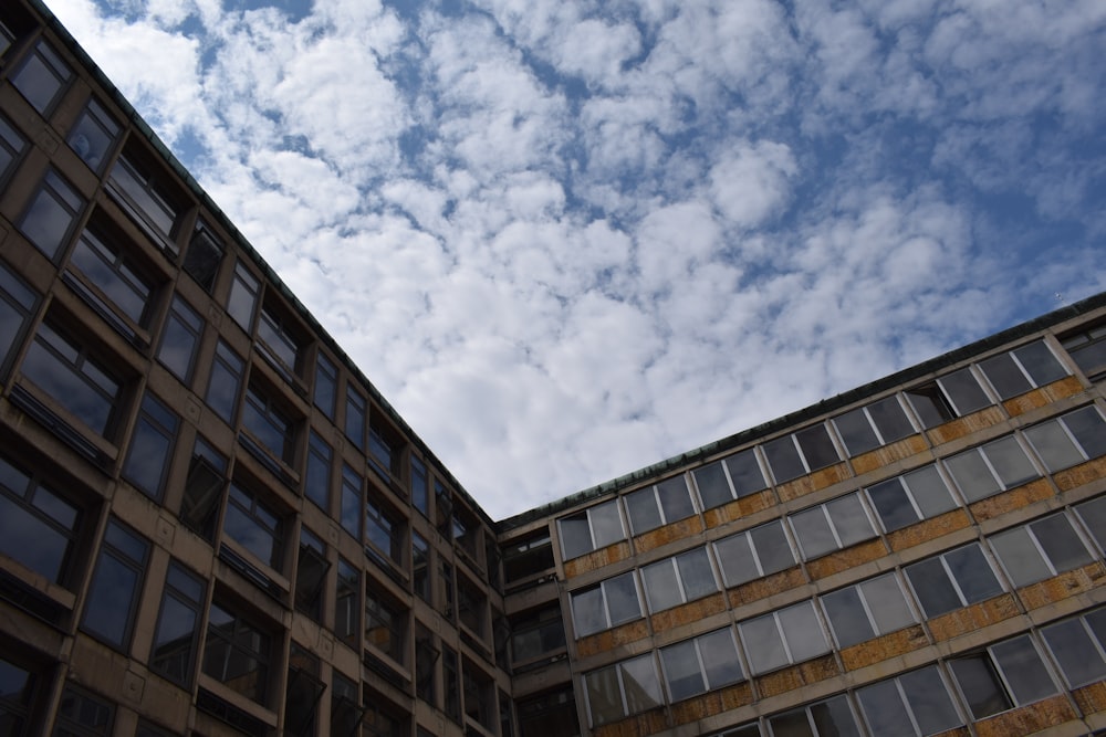 brown concrete building under white clouds and blue sky during daytime