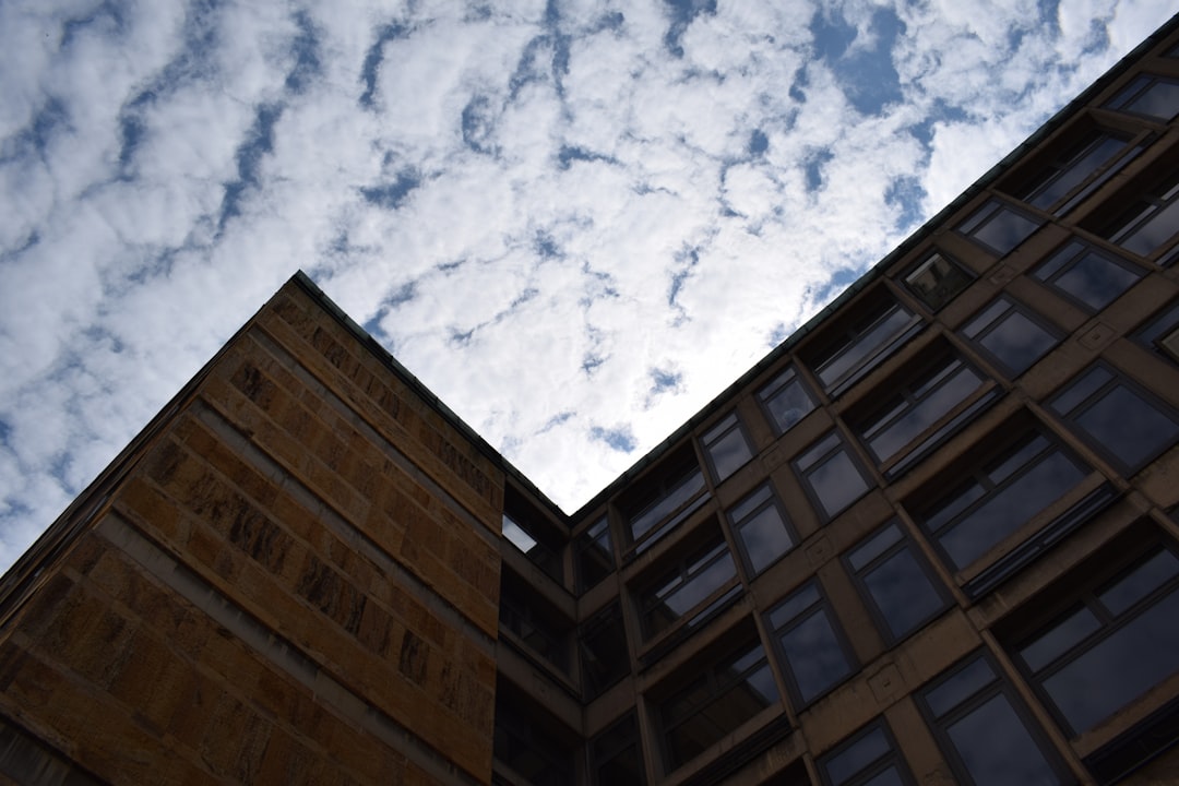 brown concrete building under white clouds and blue sky during daytime