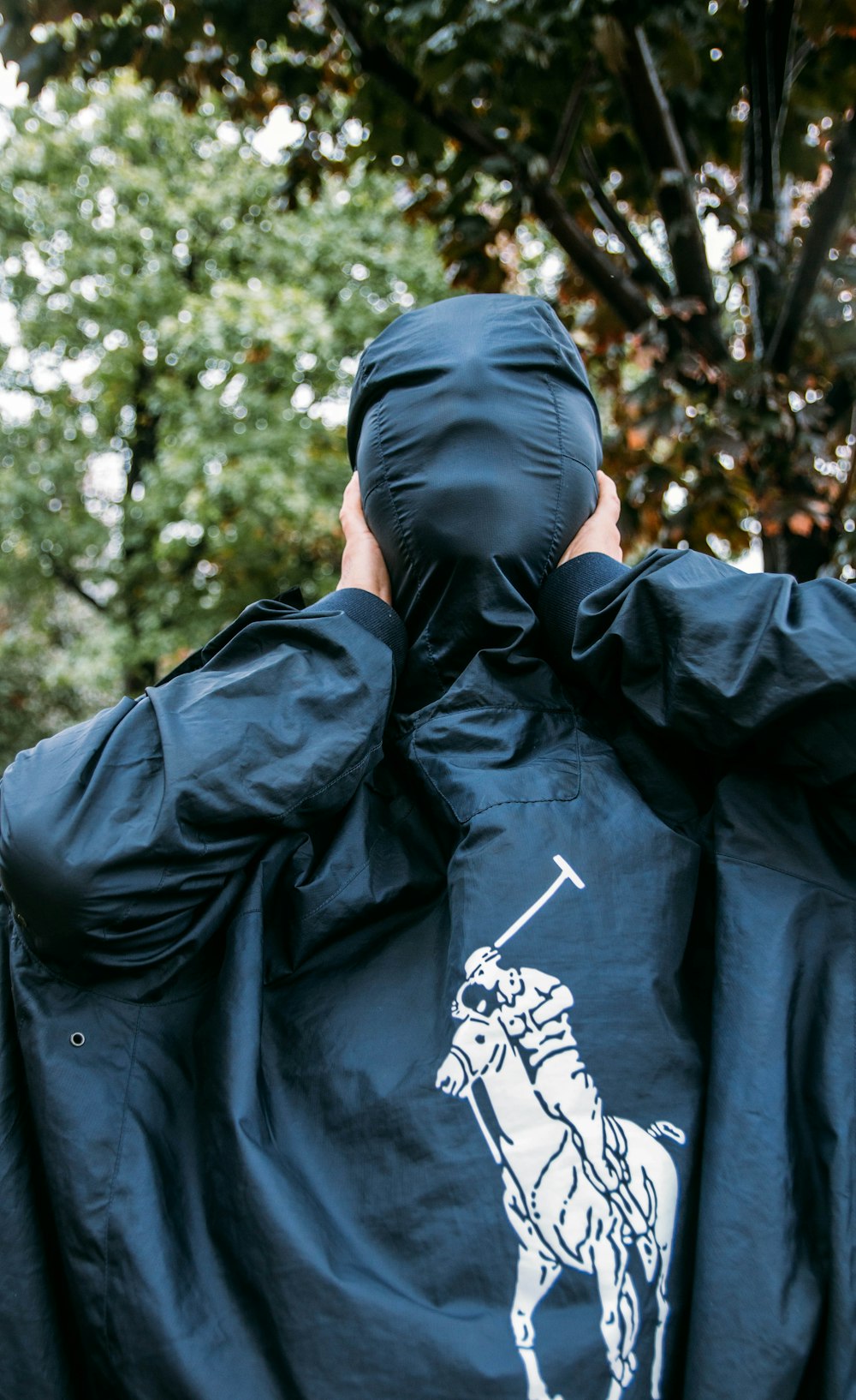 man in black hoodie covering face with hands