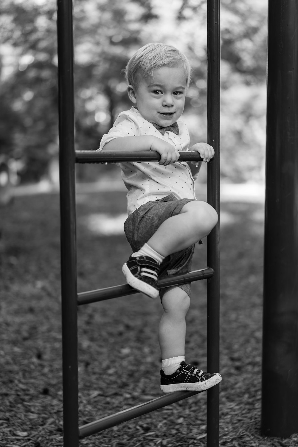 grayscale photo of baby sitting on swing