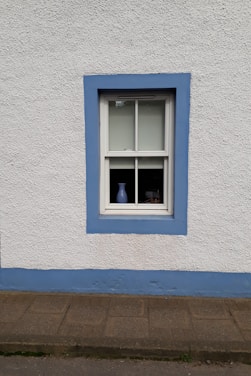 blue wooden window frame on white concrete wall