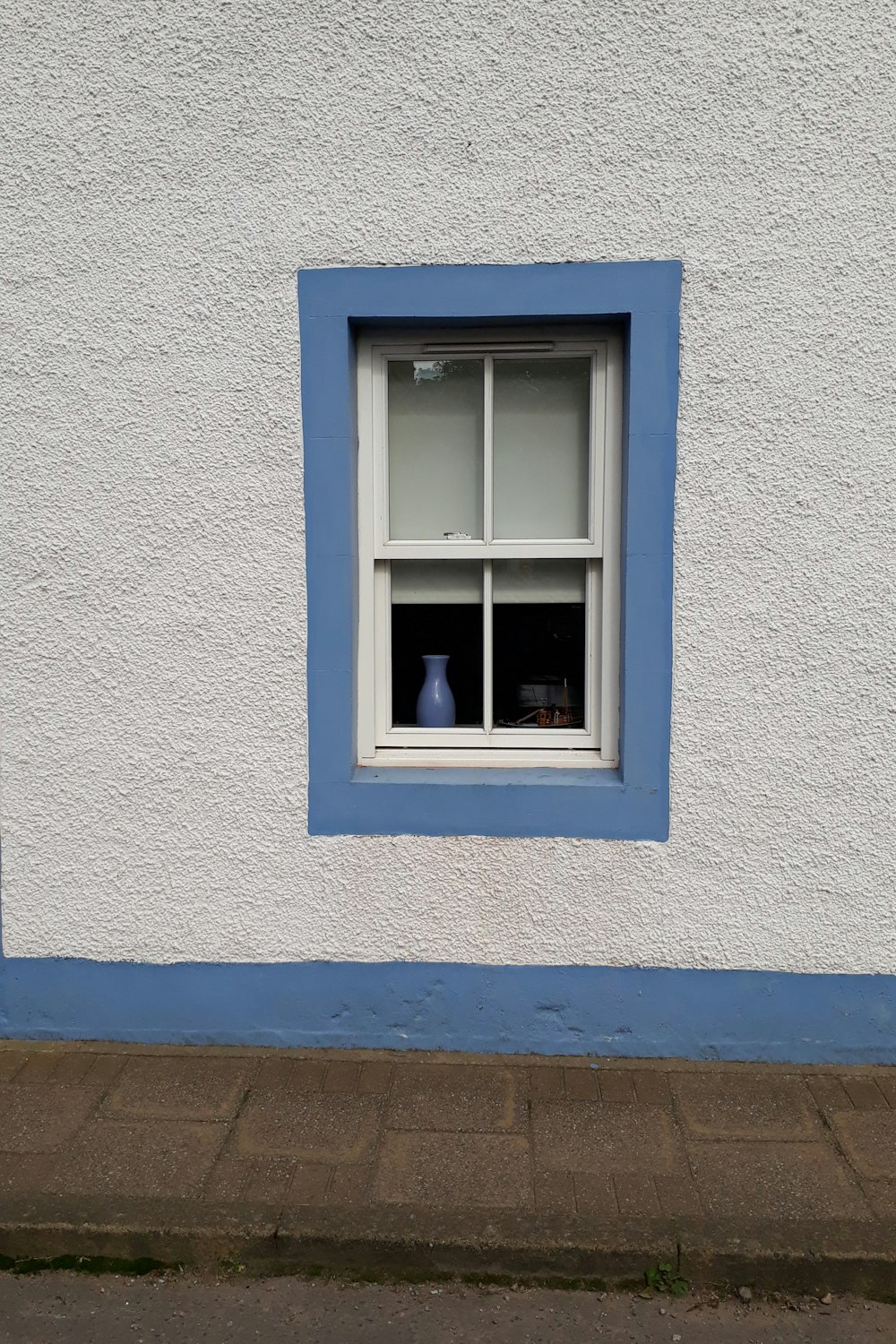 blue wooden window frame on white concrete wall