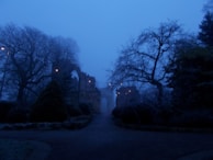An eerie abandoned village under a twilight sky, with flickering lanterns casting long shadows.