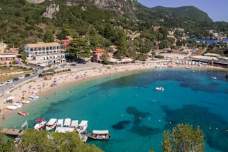 aerial view of boats on sea near green mountain during daytime