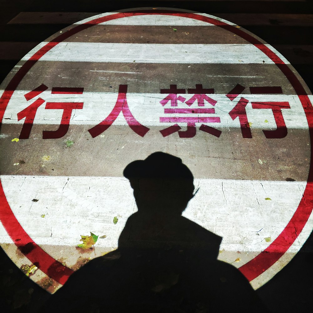 man in black jacket standing on gray concrete floor