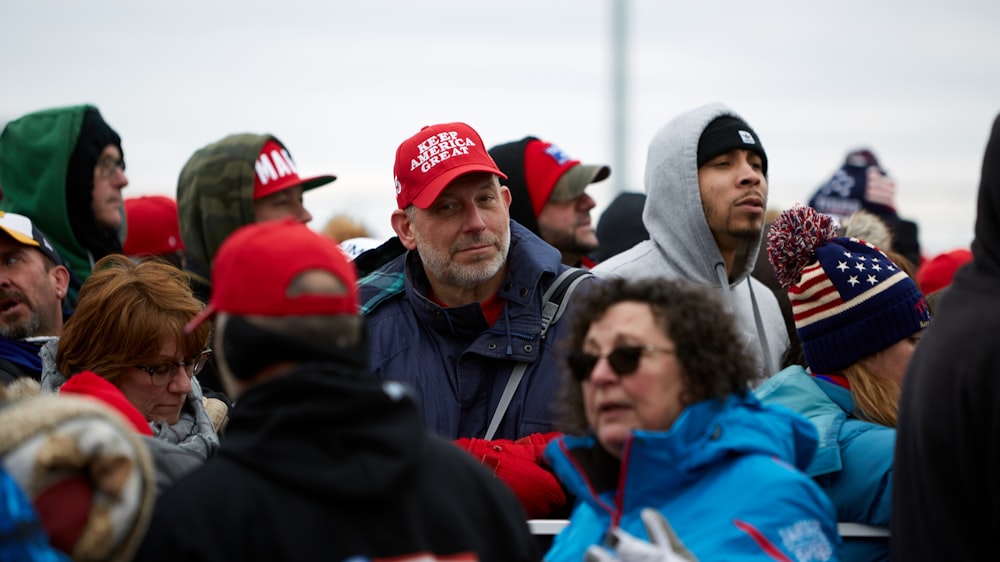 groupe de personnes en casquette rouge et veste bleue