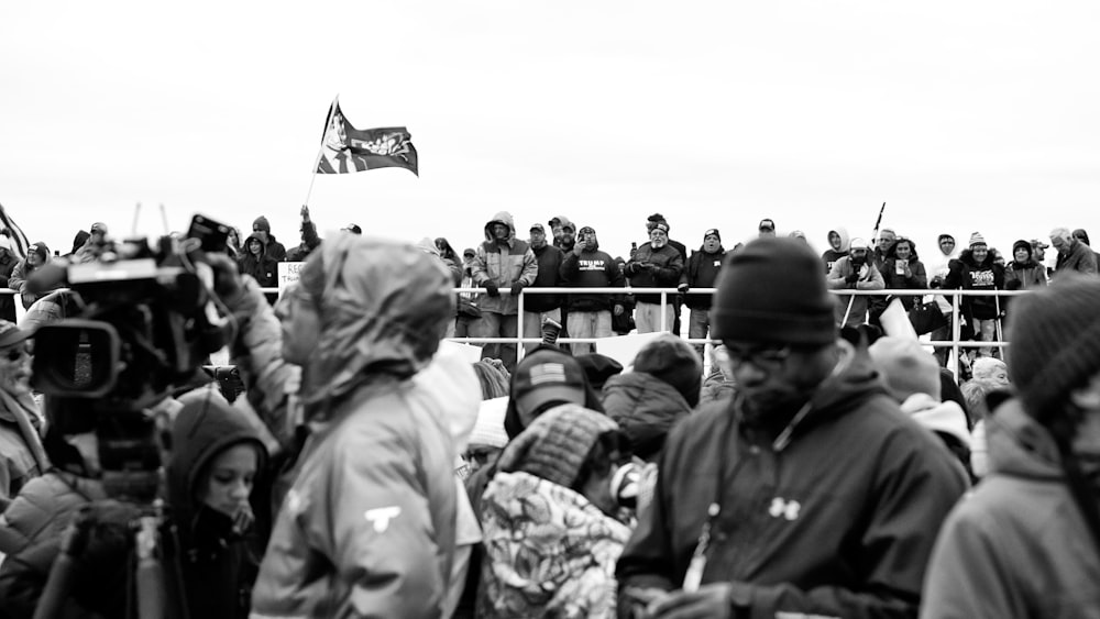 grayscale photo of people gathering on field