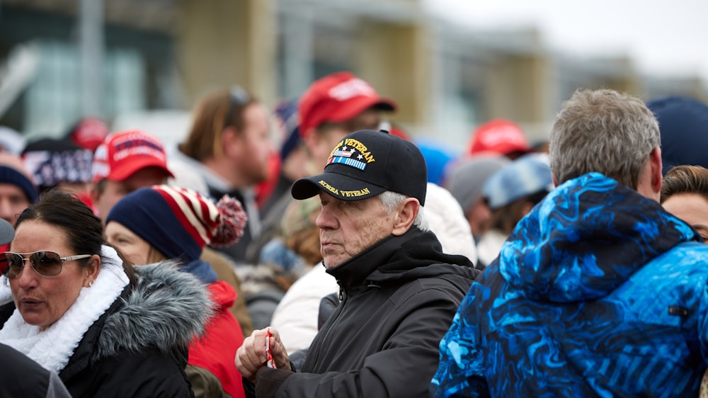 hombre con chaqueta negra con gorra azul