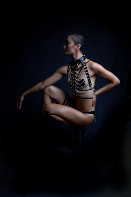Close-up of a sleek, adjustable body-harness sculpting a woman's silhouette with metallic precision.