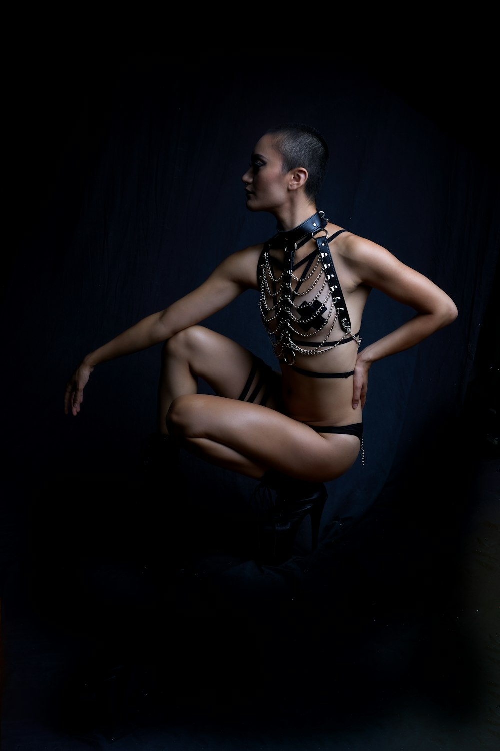 woman in black brassiere and panty set sitting on black textile