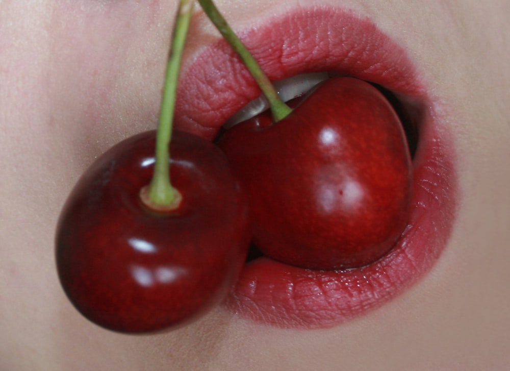 2 red cherries on white textile