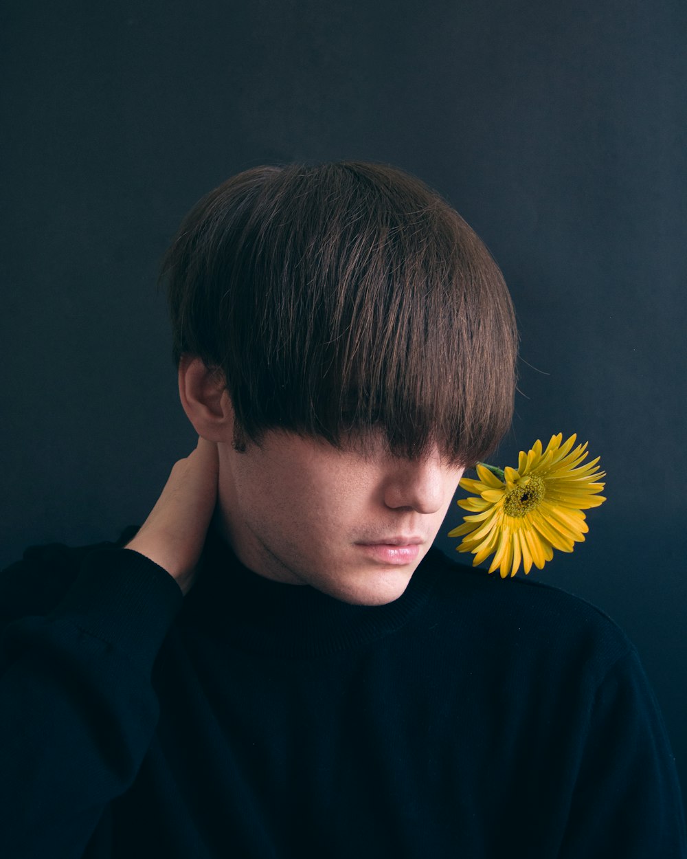 man in black crew neck shirt with sunflower on his ear
