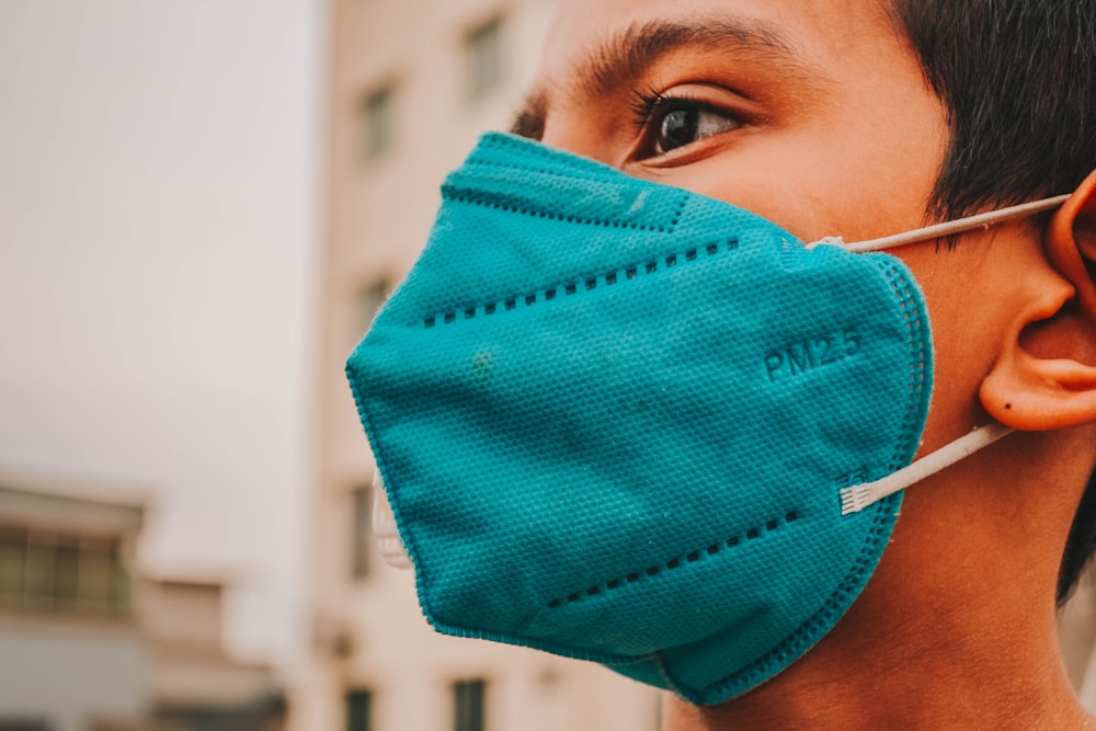 woman in blue tank top covering her face with blue textile