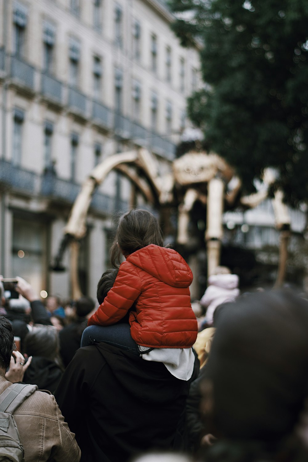 woman in red jacket and black pants sitting on the ground