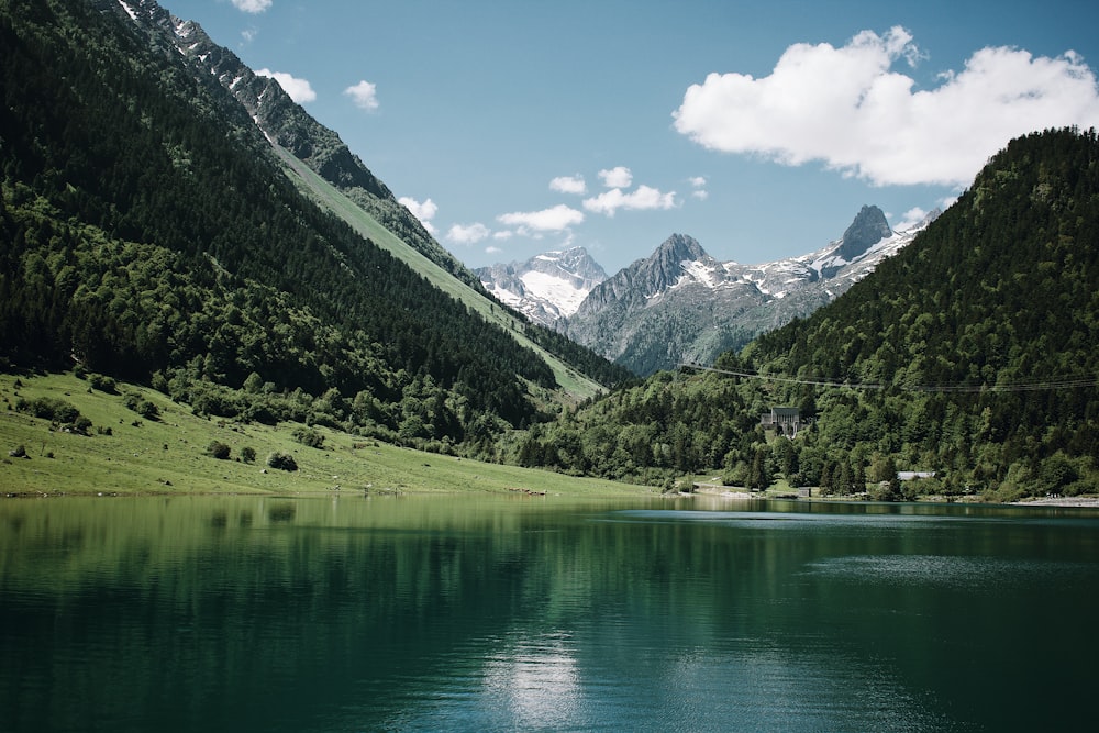 Montañas verdes junto al lago bajo el cielo azul durante el día
