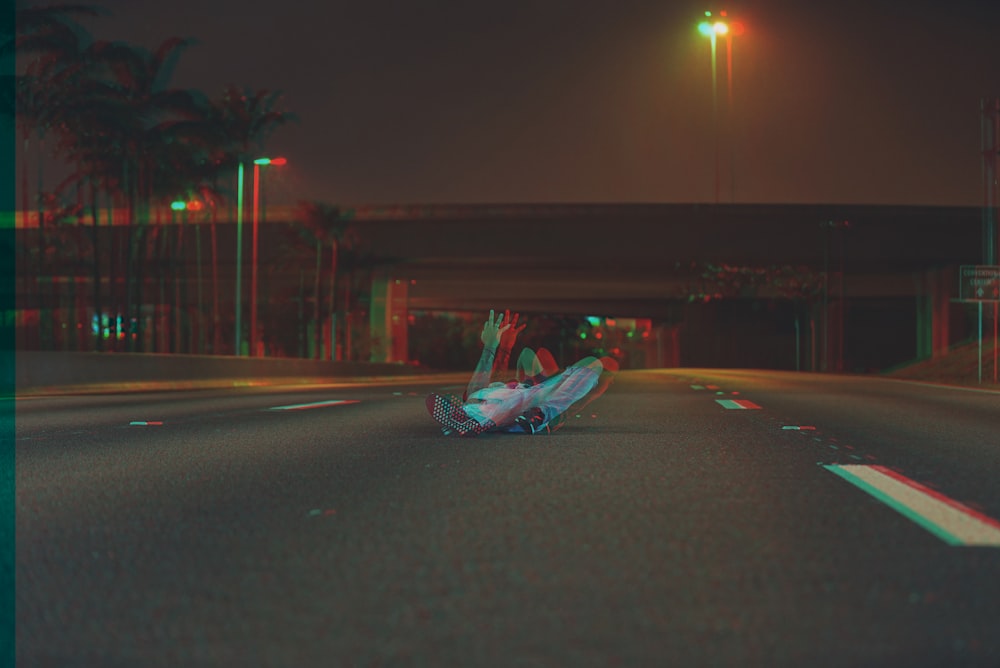 person lying on the road during night time