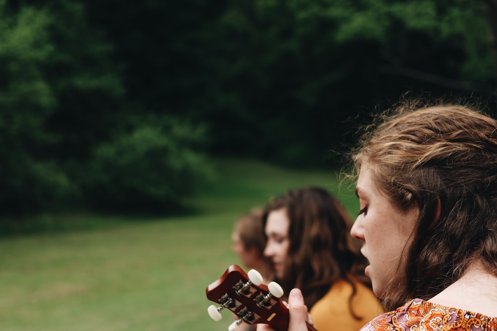 woman playing guitar during daytime