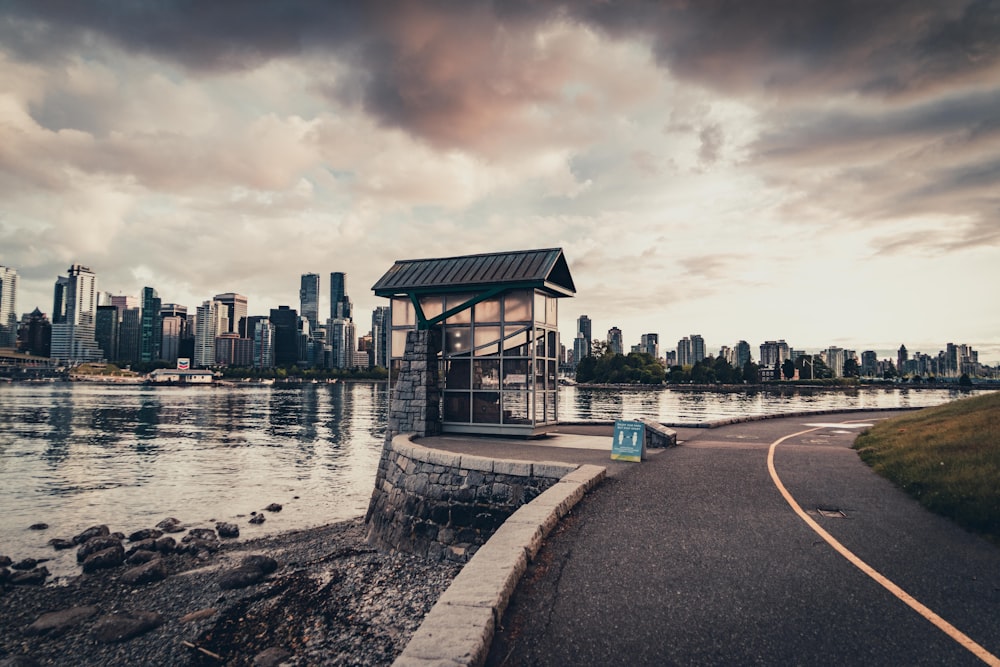 brown wooden house near body of water under cloudy sky during daytime