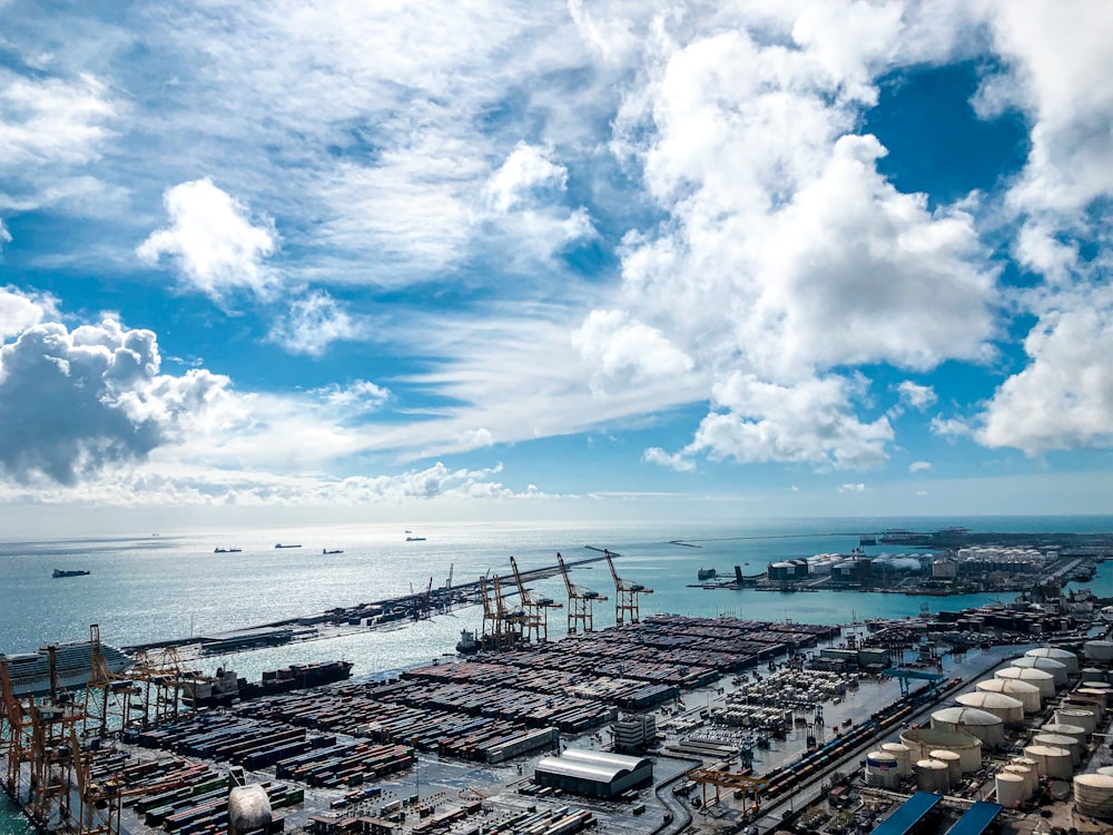 city buildings near sea under blue and white cloudy sky during daytime