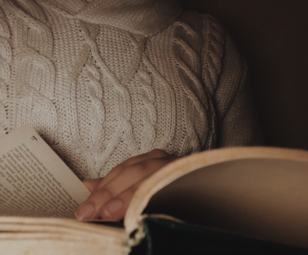 person holding white and brown textile