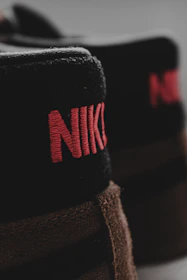 Close-up of a Nike shoe’s intricate stitching and luxurious materials under soft lighting.