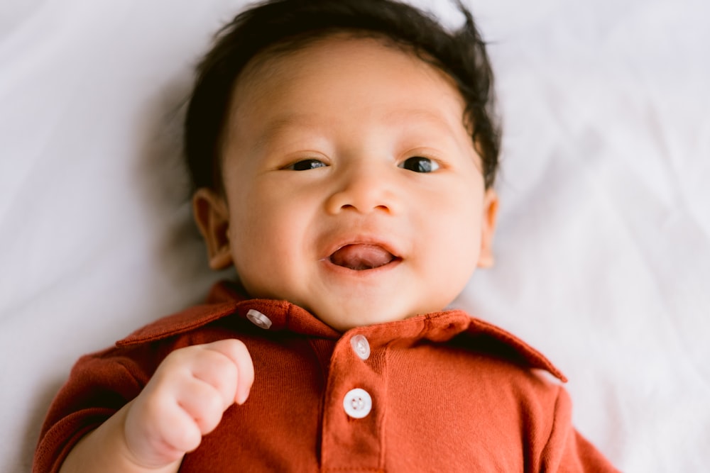 baby in red button up shirt