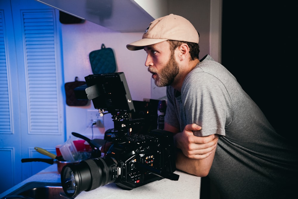 man in gray crew neck shirt holding black video camera