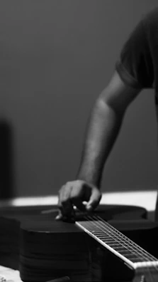Black-and-white candid of a mandolin player tuning up before an interview.