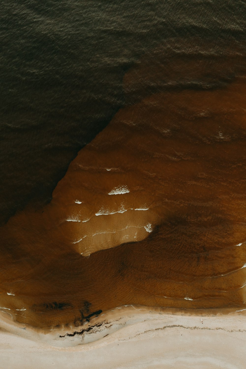 brown sand with water during daytime