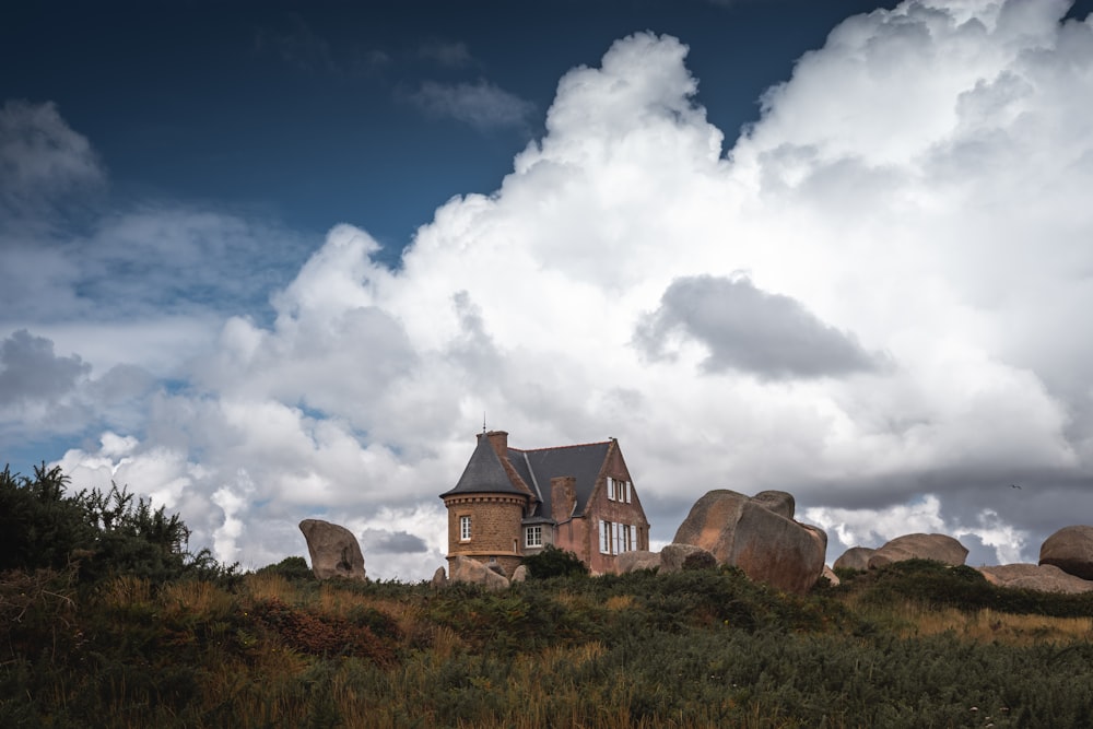 brown concrete house under white clouds and blue sky during daytime