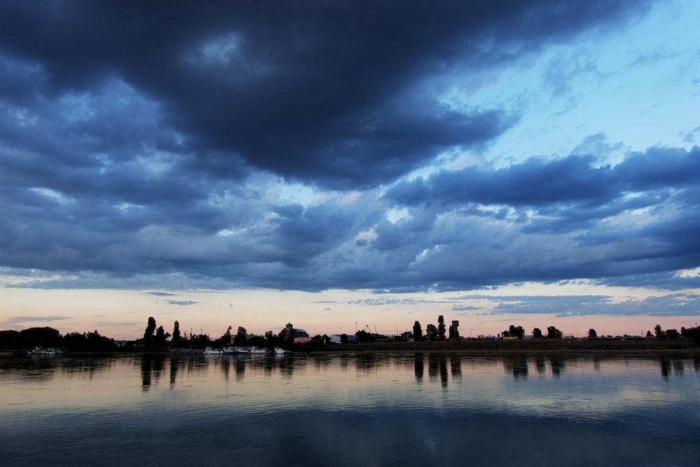 silhouette of people on beach under cloudy sky during daytime