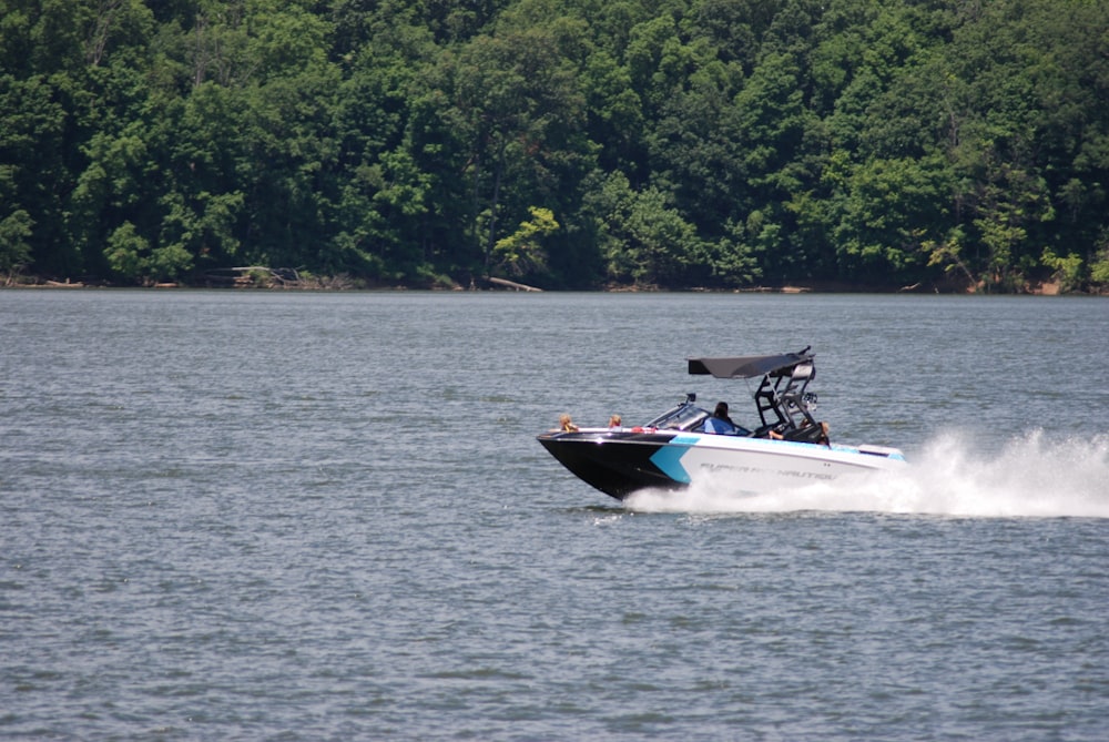 person riding white and black personal watercraft on body of water during daytime