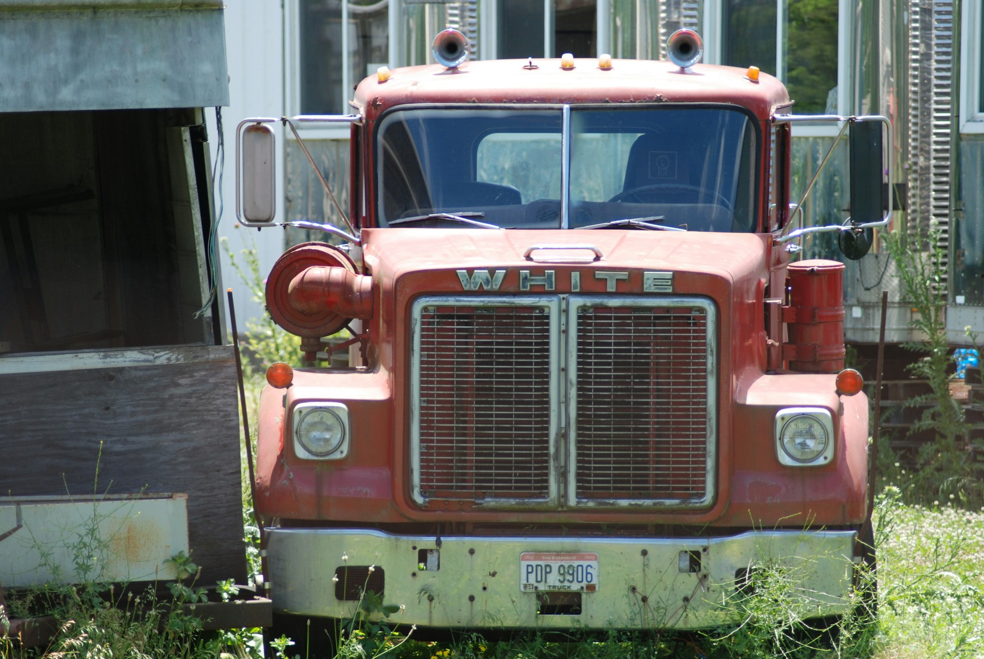 red and white truck in front of white building