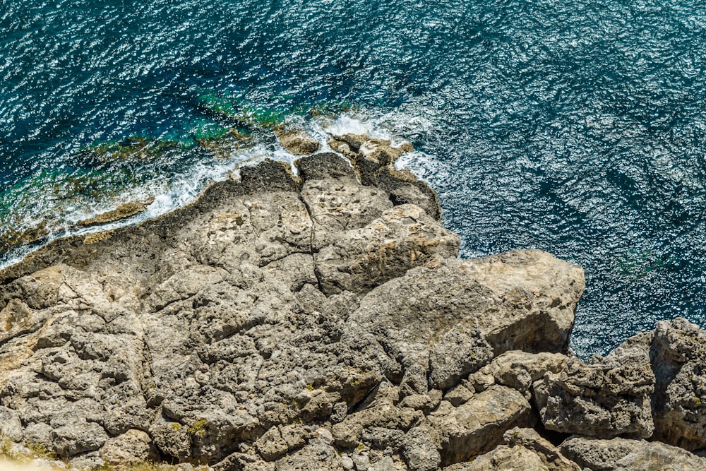 Formation rocheuse brune au bord de la mer bleue pendant la journée