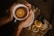 Close-up of hands gently holding a cup of tisaani’s Soul Ground tea with dried botanicals nearby.