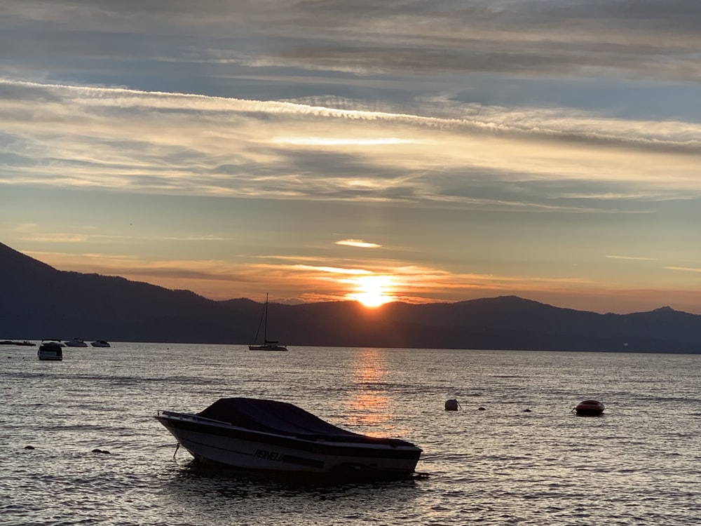 silhouette of boat on sea during sunset