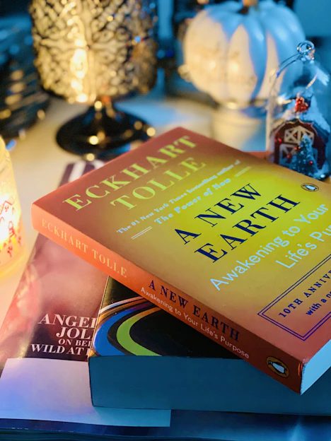 A cozy workspace with books on science, spirituality, and technology, illuminated by soft warm light.