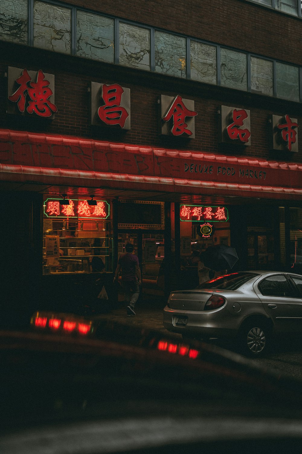 silver sedan parked in front of store during night time