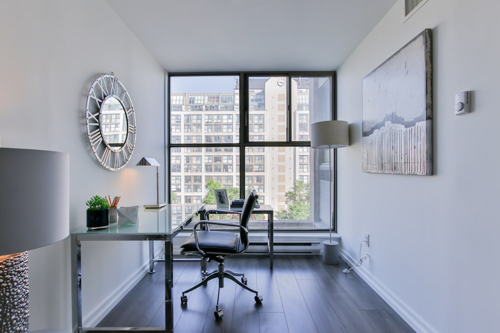 black office rolling chair beside white wooden desk