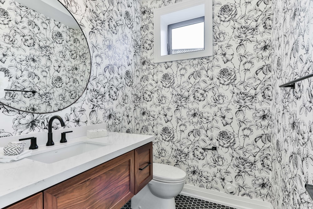 white ceramic sink beside white and black floral wall