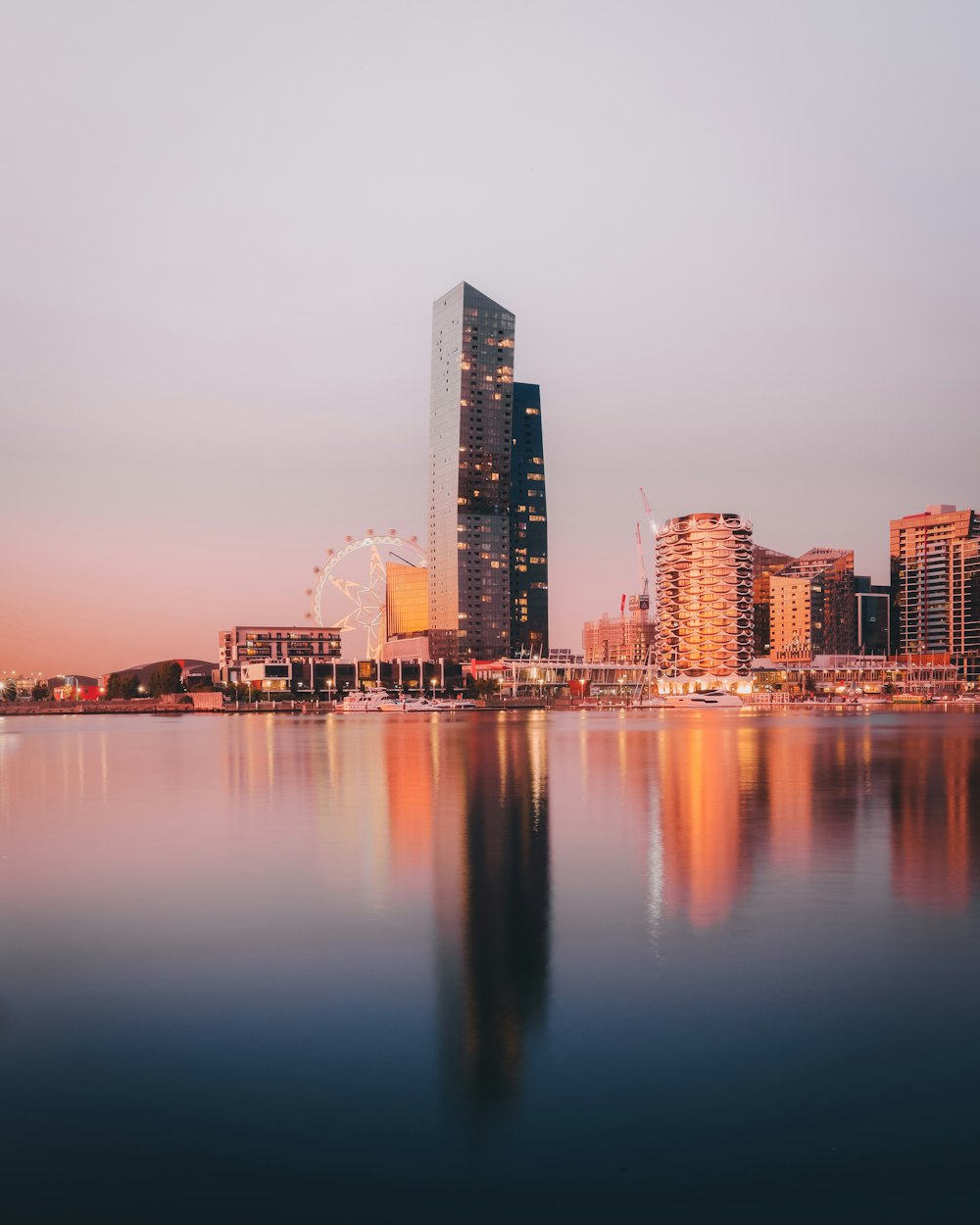 city skyline across body of water during night time