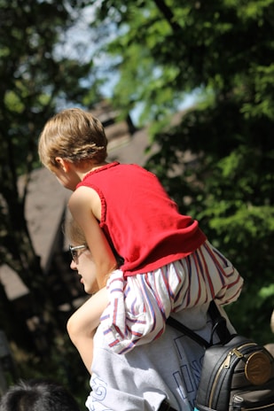 A happy parent gently wiping sunscreen off a child's face with sunbuddy wipes, both relaxed and smiling.