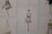 The image contains a series of fashion sketches displayed on a wall. Each sketch features abstract, stylistic drawings of women in various fashionable dresses. The artwork is monochromatic and uses a minimalistic design approach.