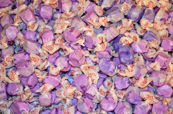 A collection of customized party supplies featuring purple-themed designs and names.